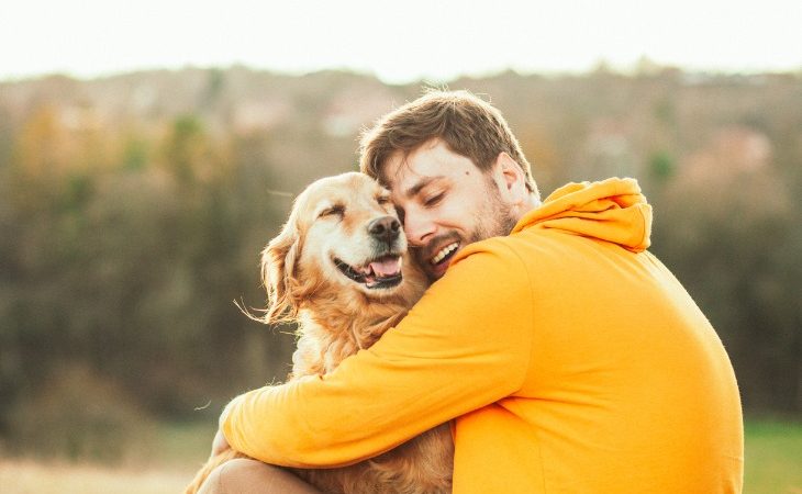 Chien qui fait un câlin à son maître