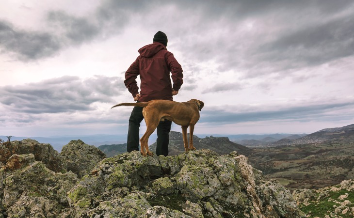 dueño con su perro en la montaña