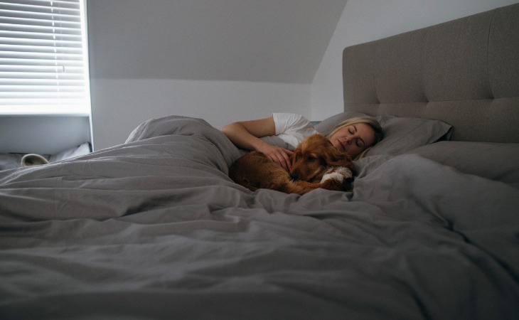 mujer durmiendo con perro